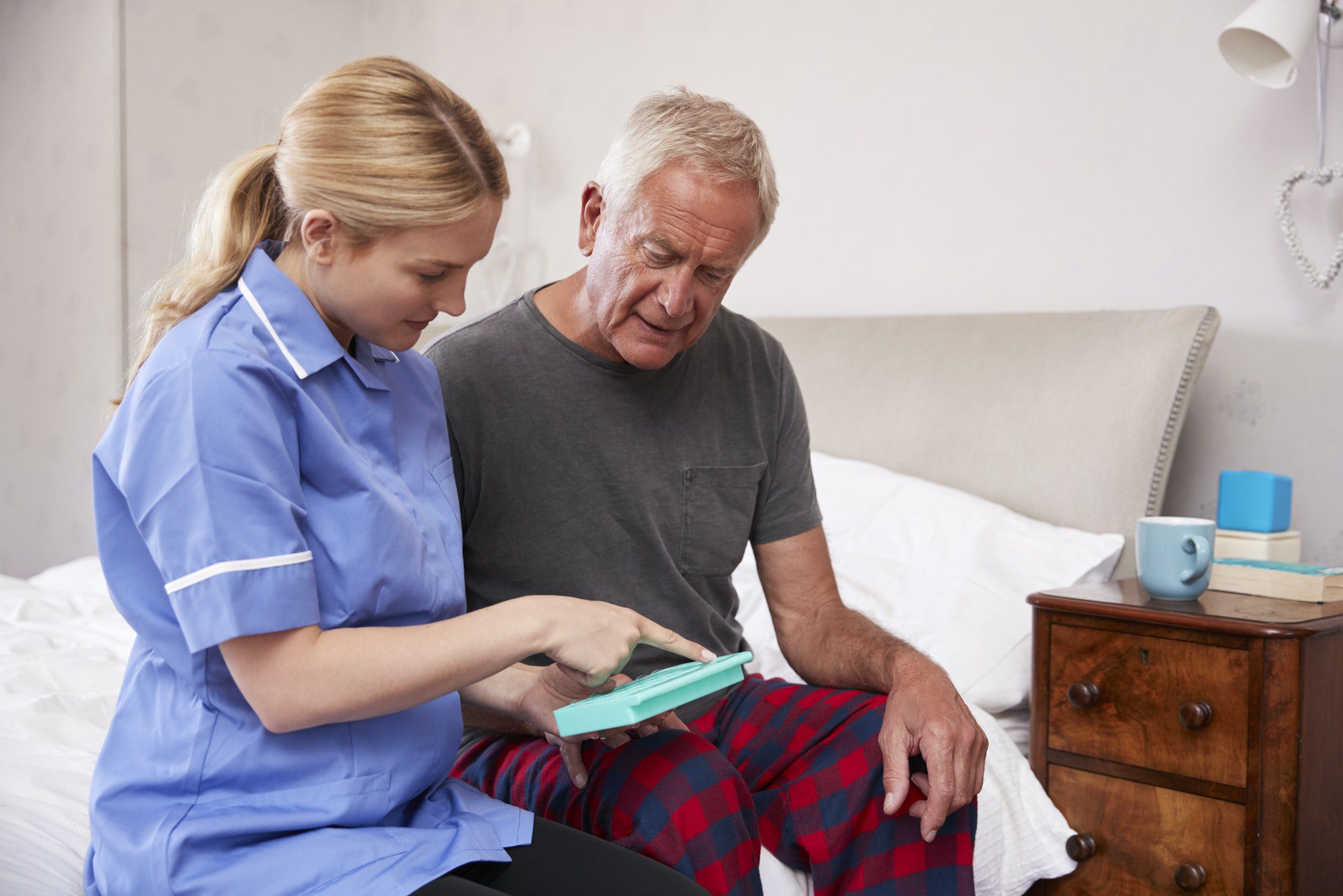Nurse Helping Senior Man To Organize Medication and explaining how to avoid paying a penalty.