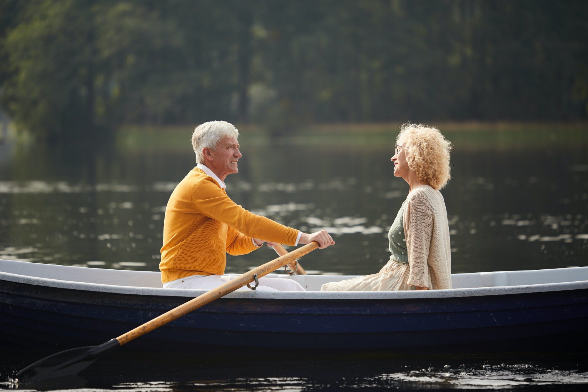 Happy senior couple riding boat as they discuss their Medicare Plan G.