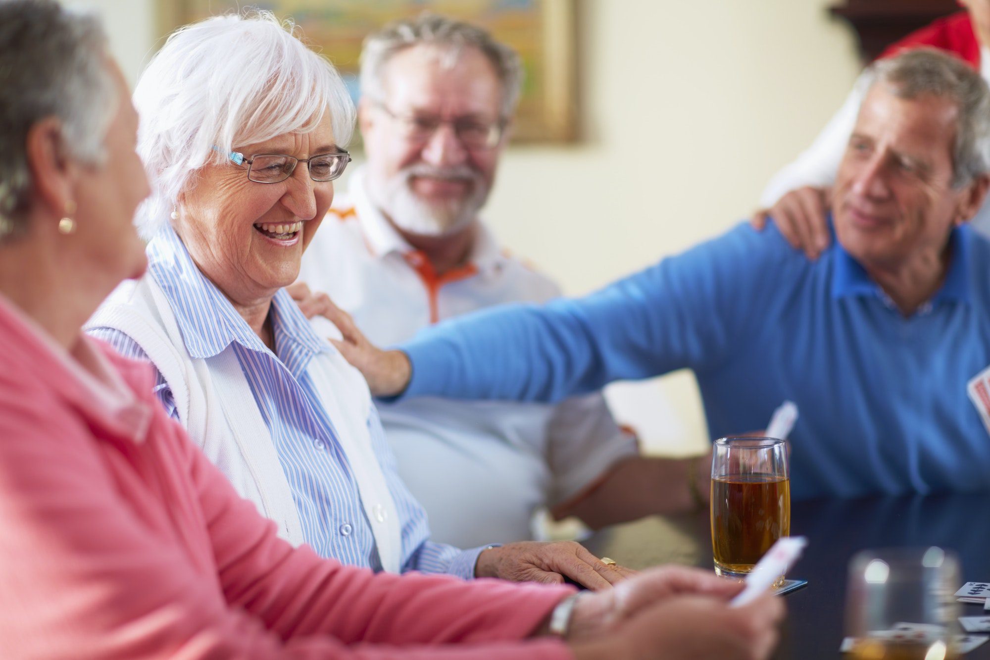 Senior friends in Florida enjoying playing cards together as they discuss the medicare options in the state.