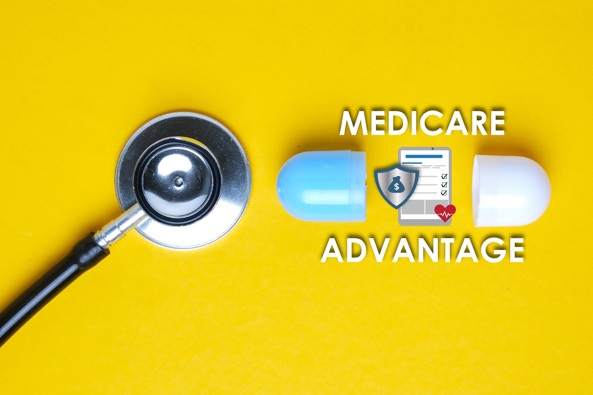 A picture of stethoscope with fake capsule, Medicare Advantage (Part C of Medicare) word, tablet, money shield and heart.