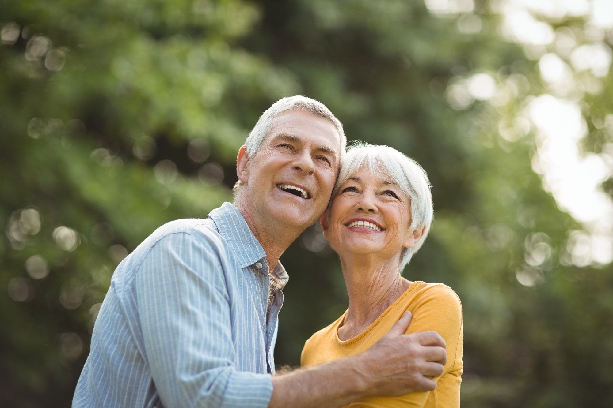 Happy senior couple in park discussing their Medicare Plan G.