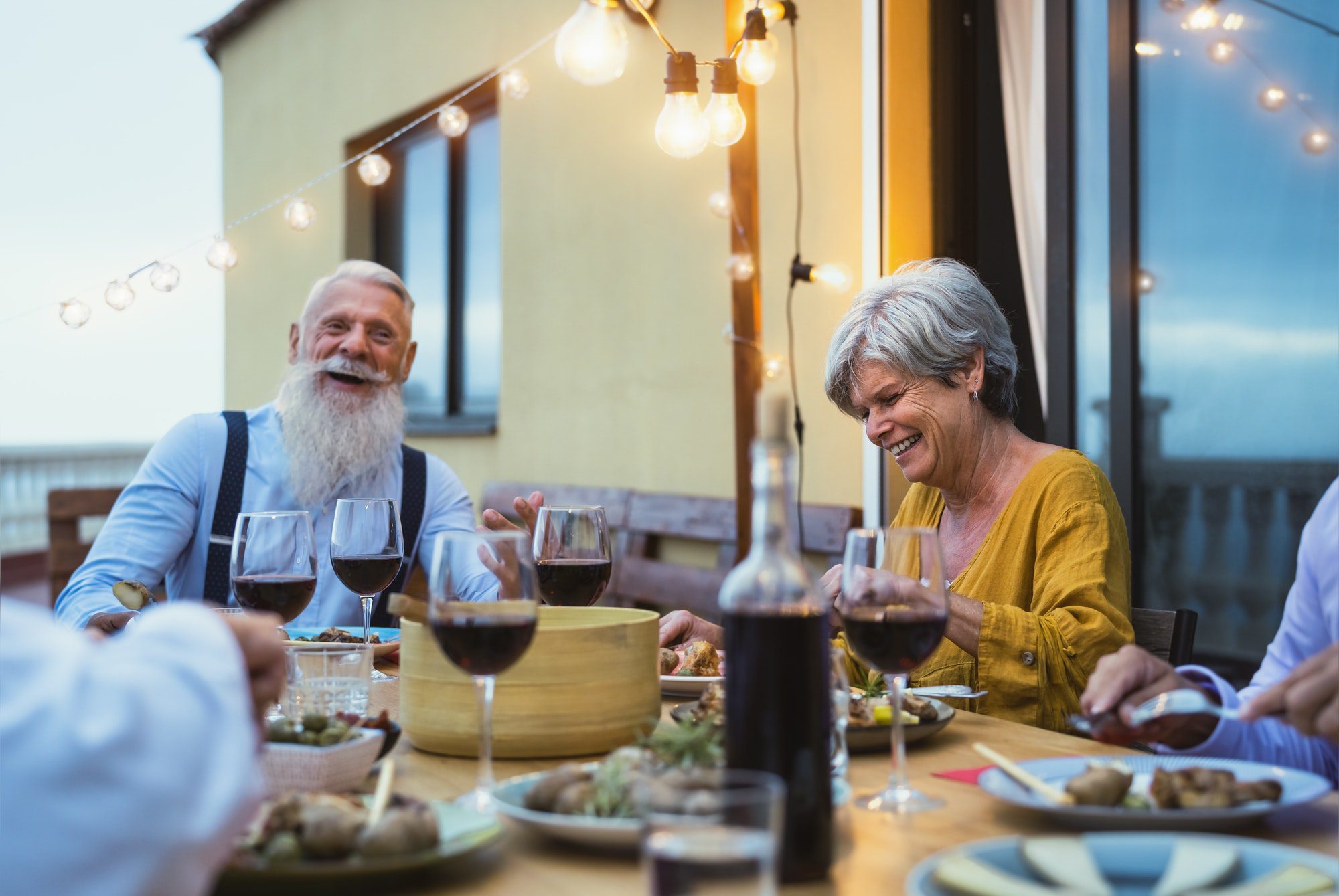 Happy seniors enjoying dinner with friends as they discuss the Medigap plans available.