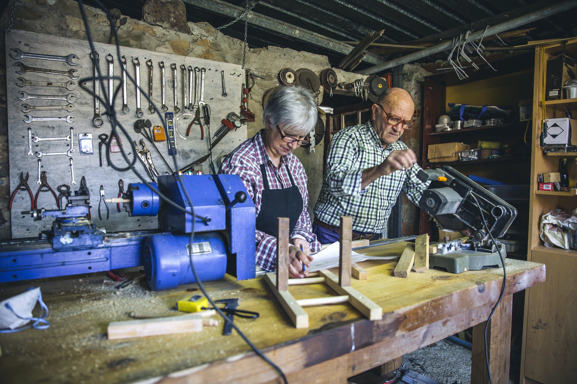 Senior couple doing wood work together last they discuss how to maximize their social security benefits.