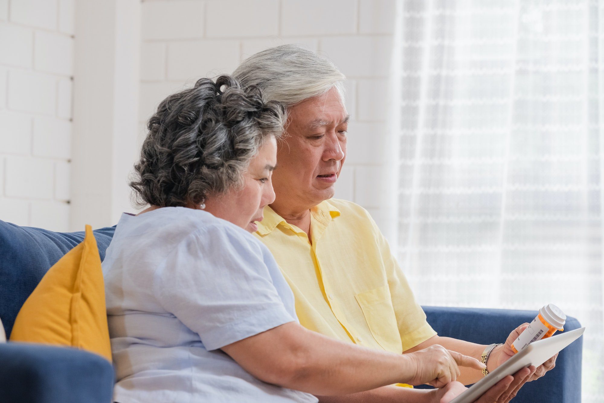 Asian senior couple use tablet searching prescription of pill with Part D Medicare Plan