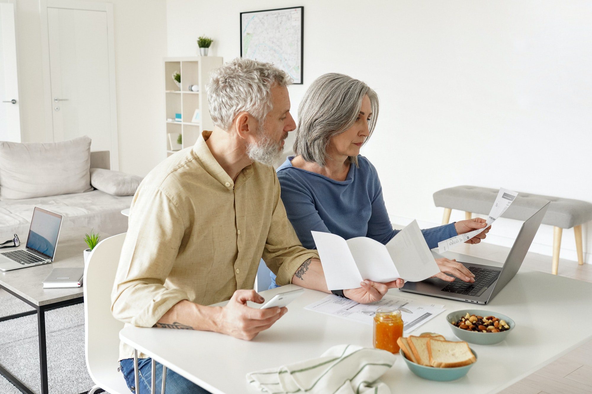 Middle aged couple paying financial bills online using computer at home wondering how much does Plan N cost?