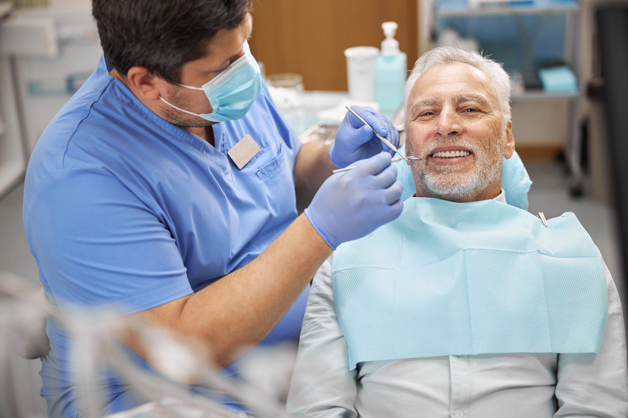 Senior patient having a dental treatment at the clinic covered under his Medicare Advantage Plan