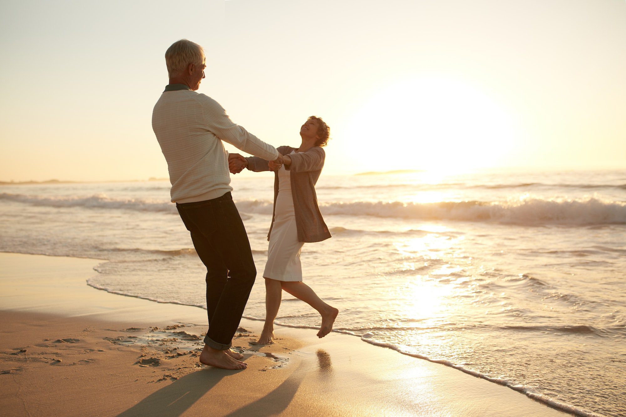 Romantic senior couple enjoying a day at the beach avoid Medicare Penalties