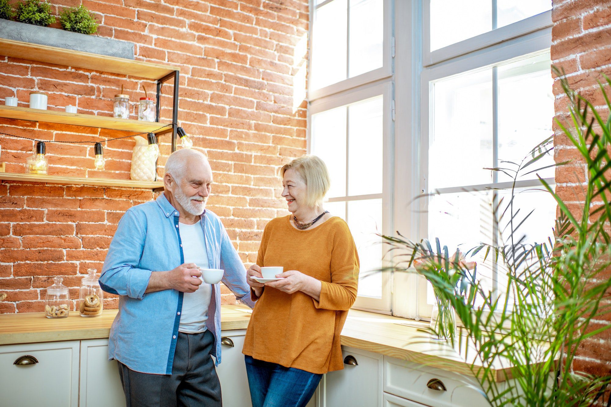 Senior couple with coffee on the kitchen at home enjoying there low-cost HMO and PPO plans