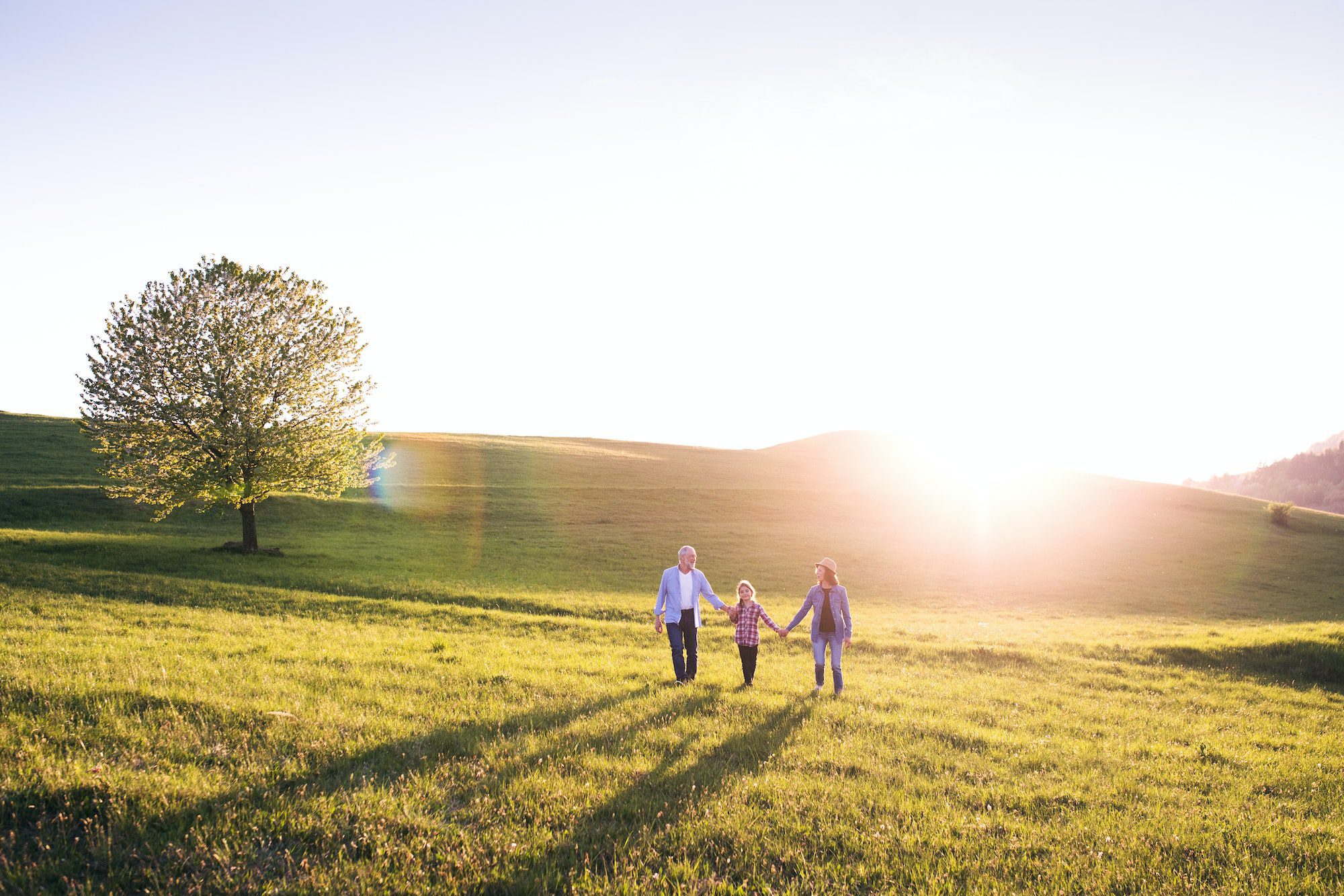 Senior couple with granddaughter outside in spring nature during AEP