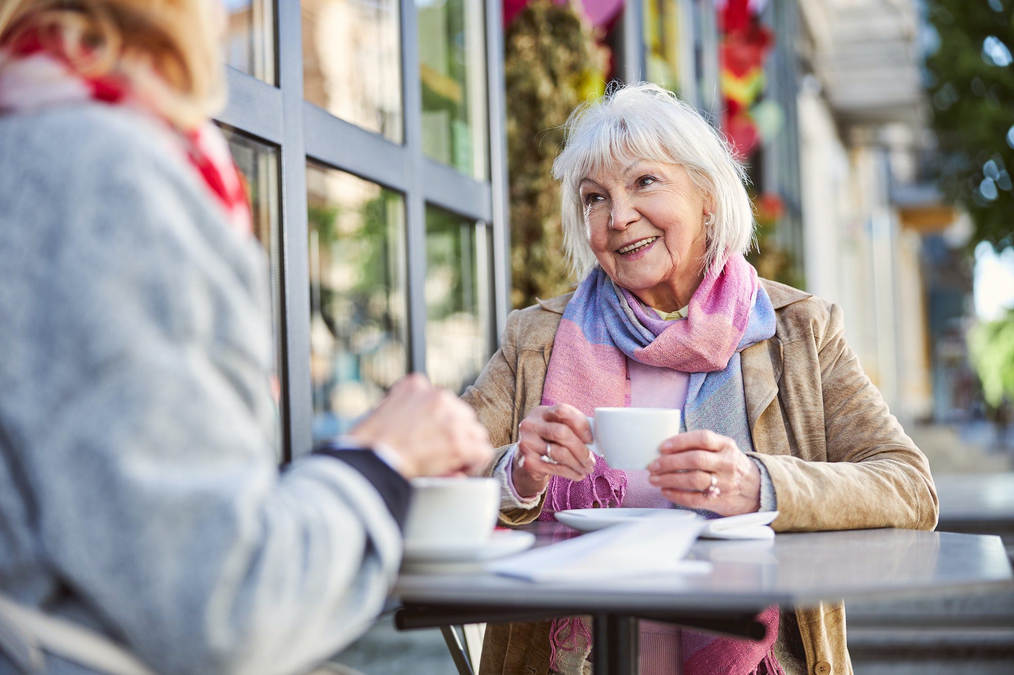 Senior woman is laughing in street cafe with Medigap Plan F